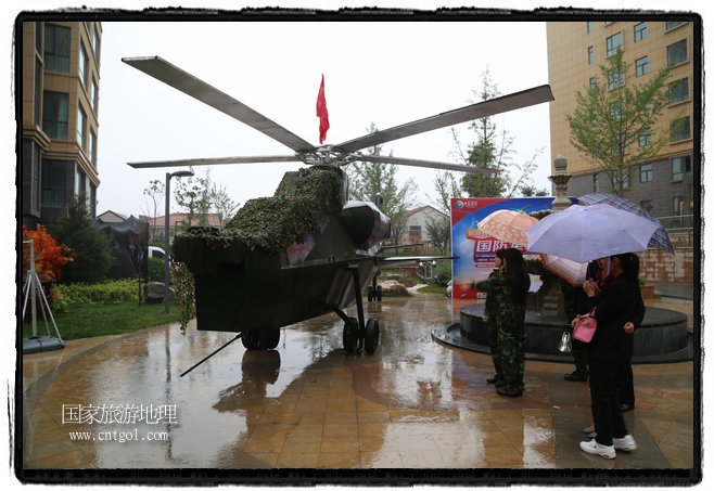 小區(qū)突然出現(xiàn)“飛機(jī)坦克”，其中殲15艦載戰(zhàn)斗機(jī)一架、99式主戰(zhàn)坦克一輛、武直-10武裝直升機(jī)一架，吸引了眾多市民雨中圍觀、合影。